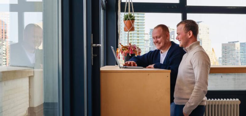 Collega's in gesprek kijkend naar een laptop